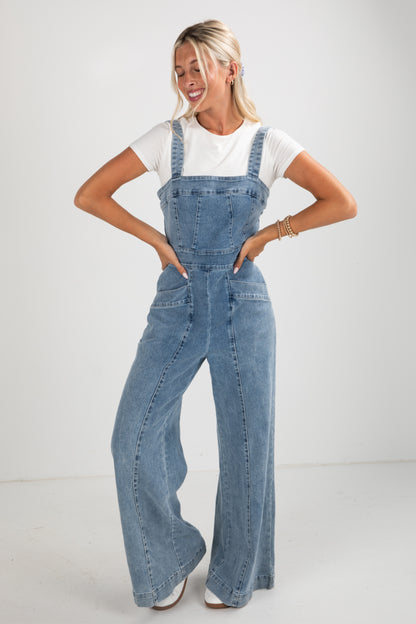 Woman wearing denim overalls on a white background