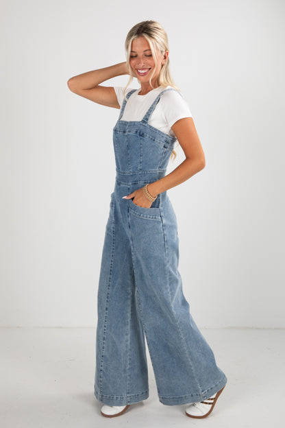 Woman wearing denim overalls on a white background
