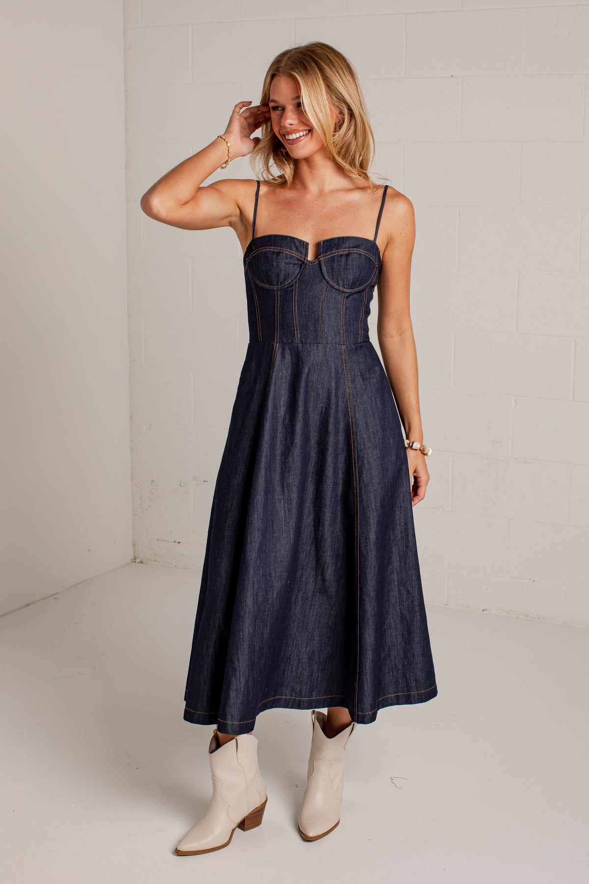 dark-wash midi dress features a strapless bustier-inspired bodice with defined seaming and a flattering fitted silhouette