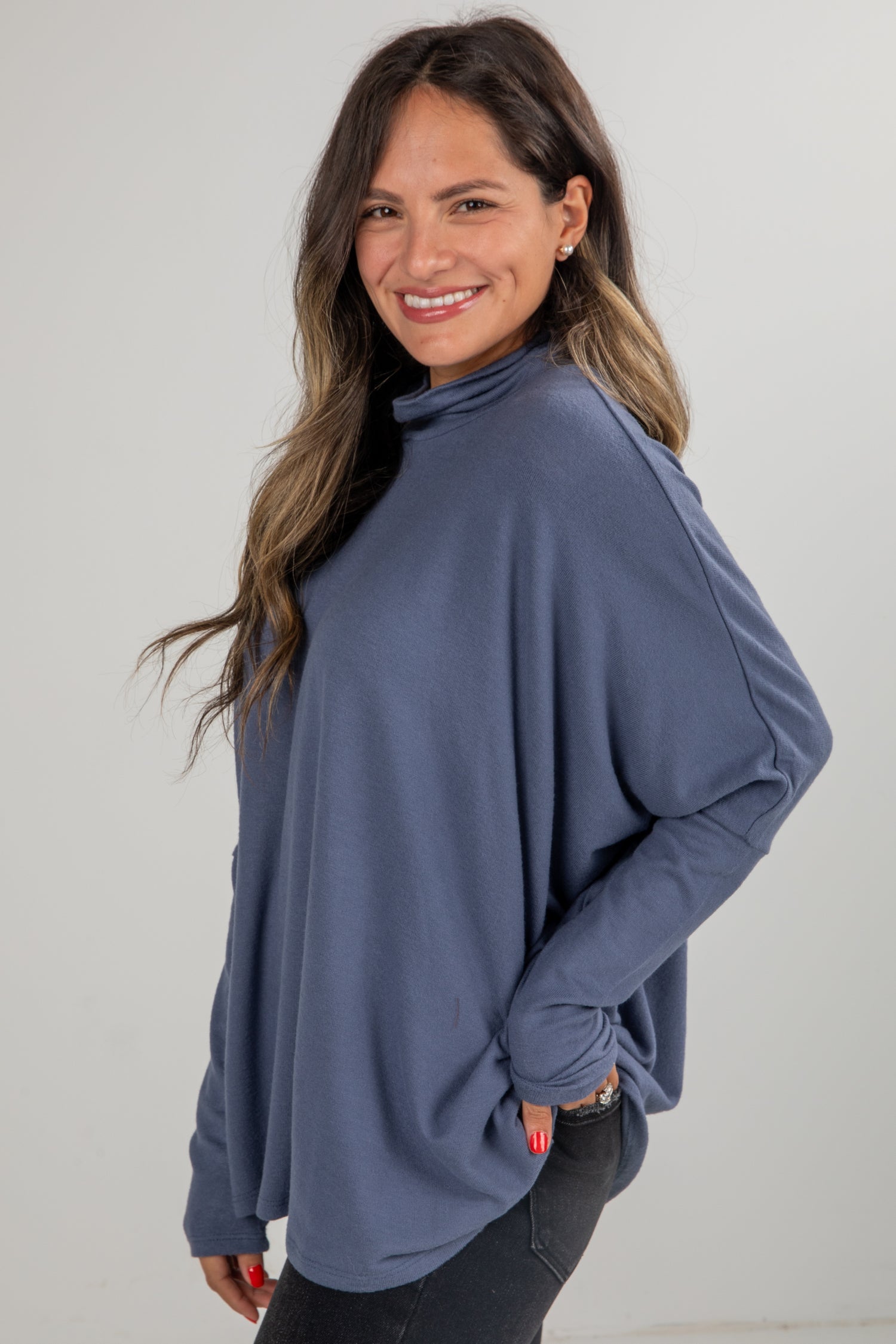 Woman wearing a blue sweater against a plain background