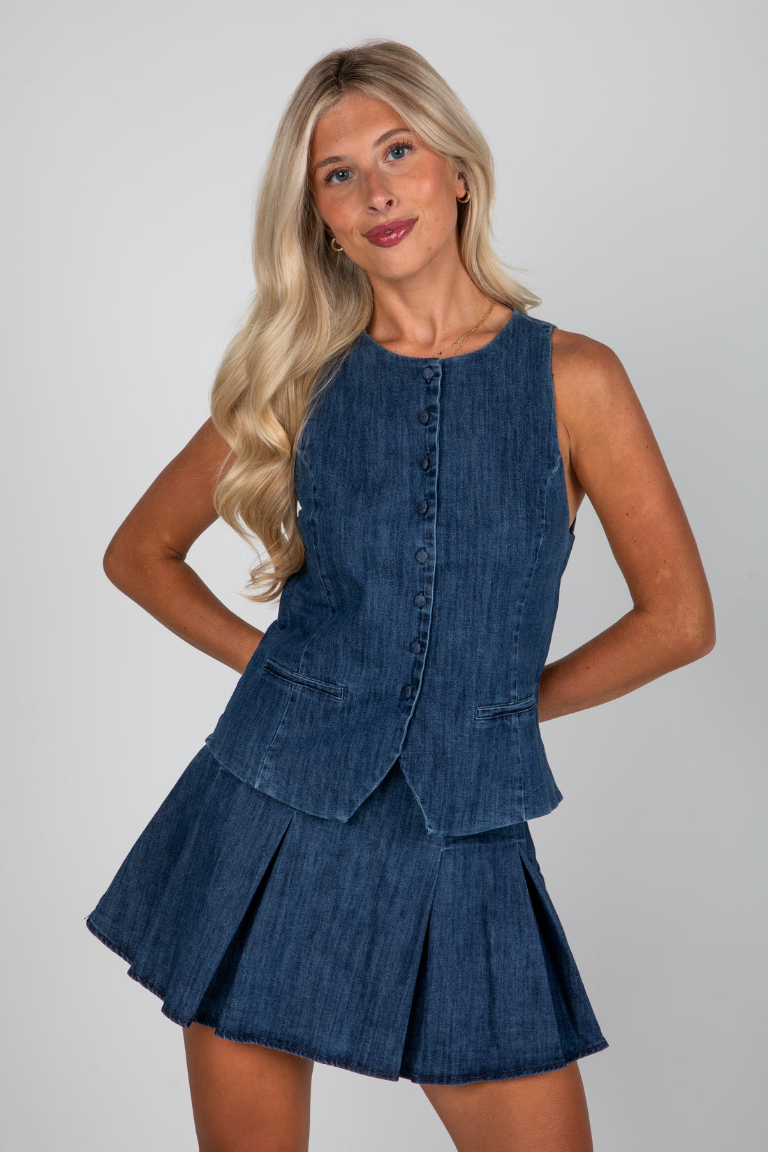 Woman wearing a blue denim dress against a plain background