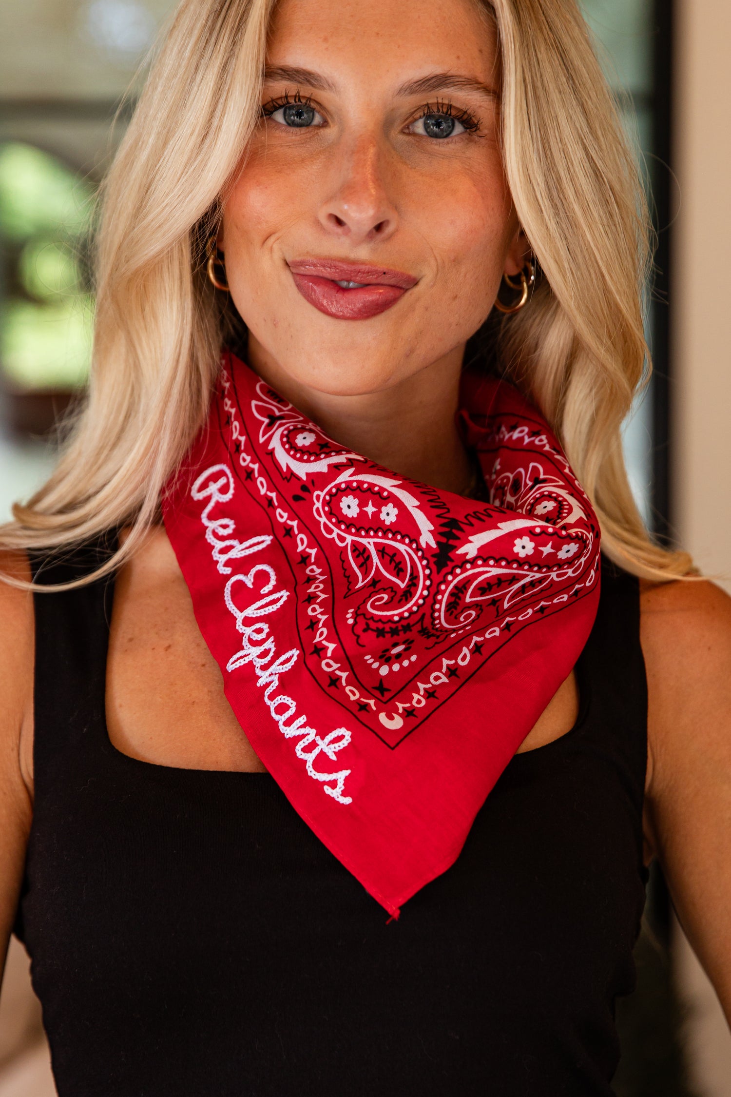 Woman wearing a red bandana with &