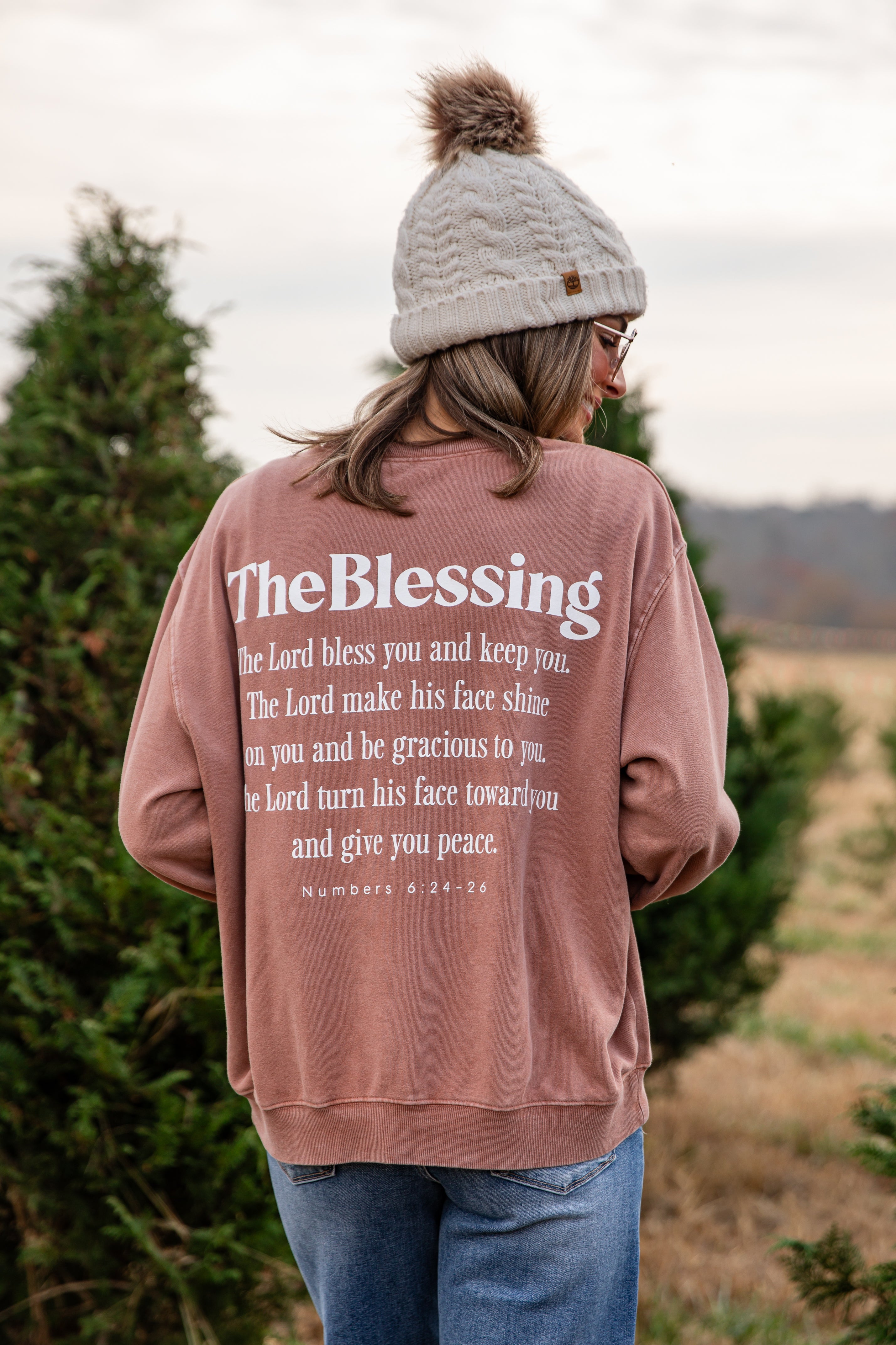 Person wearing a pink sweatshirt with &