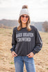 Woman wearing a dark gray sweatshirt with &
