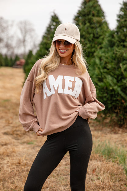 Woman wearing a beige sweatshirt with &