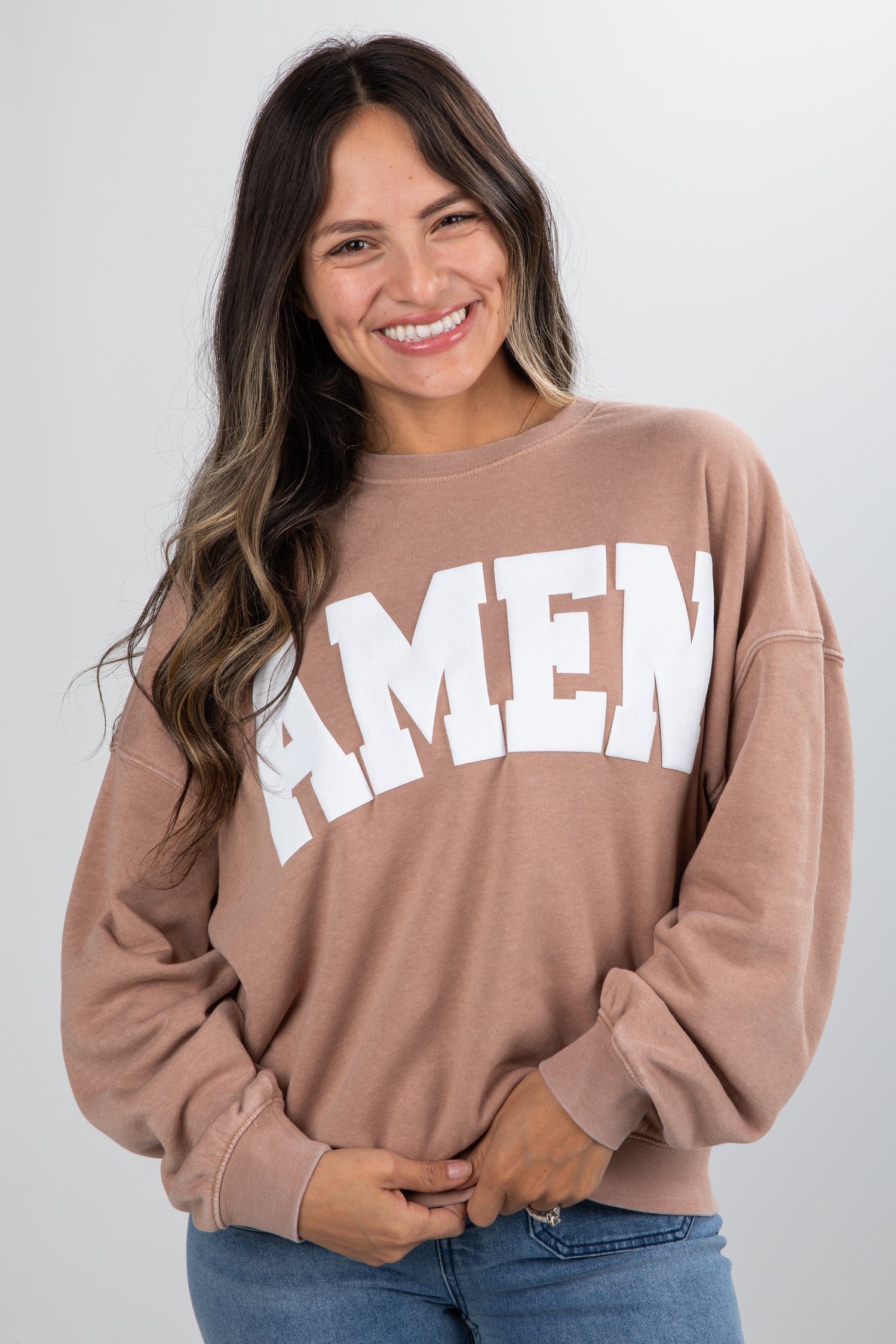 Woman wearing a brown sweatshirt with &