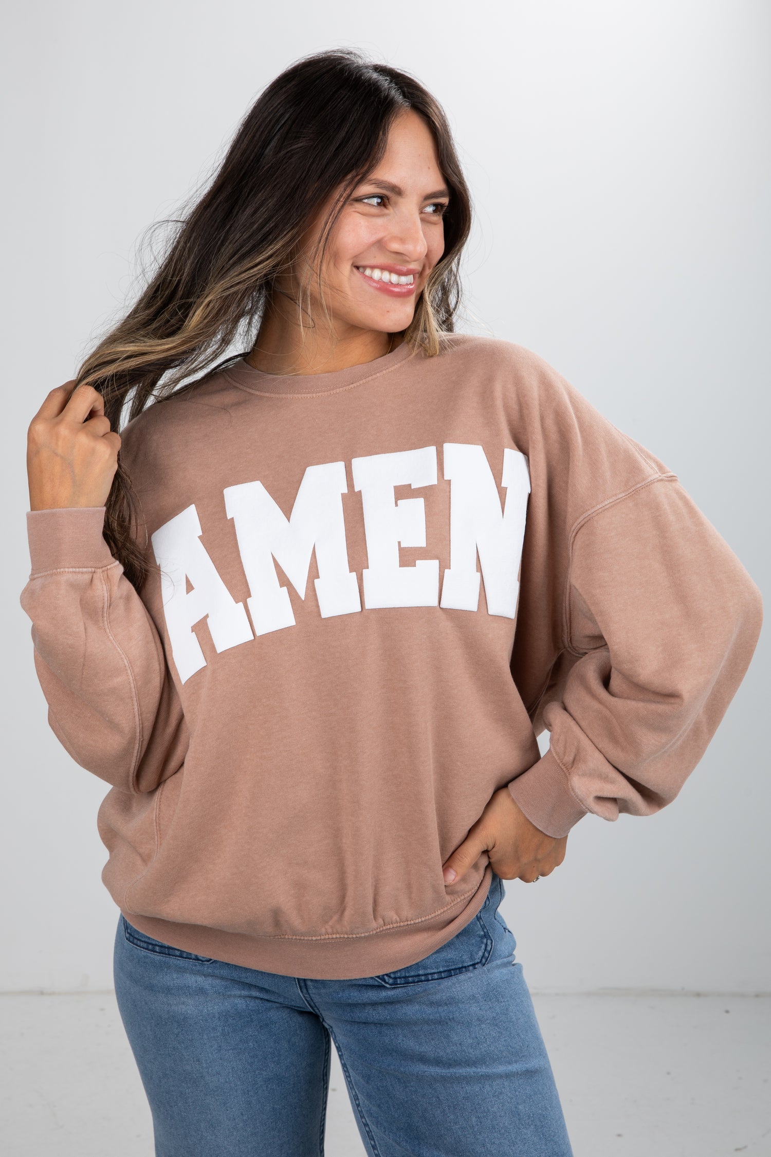 Woman wearing a brown sweatshirt with &