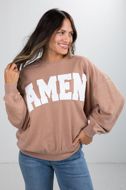 Woman wearing a brown sweatshirt with &