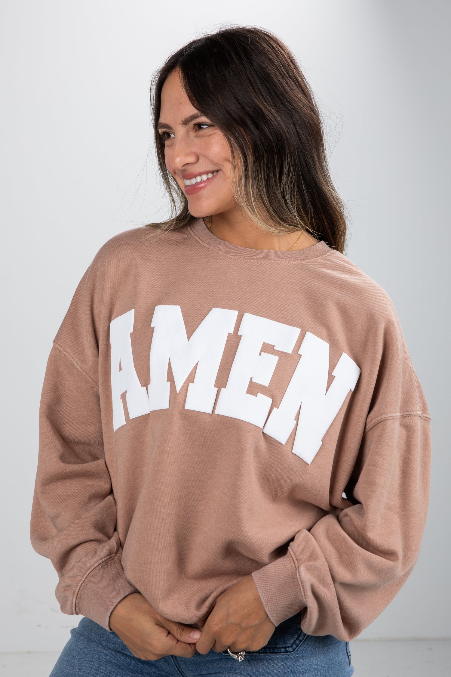 Woman wearing a brown sweatshirt with &