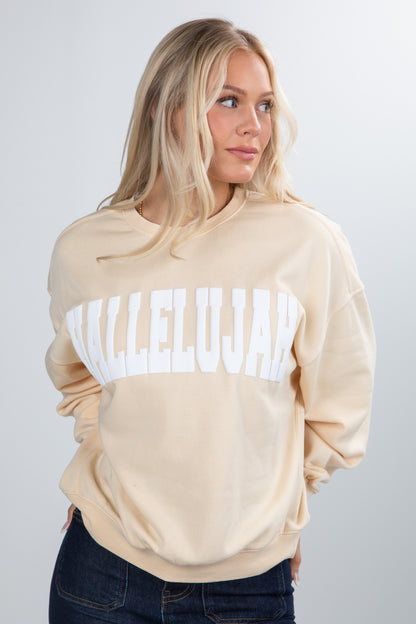 Woman wearing a beige sweatshirt with &