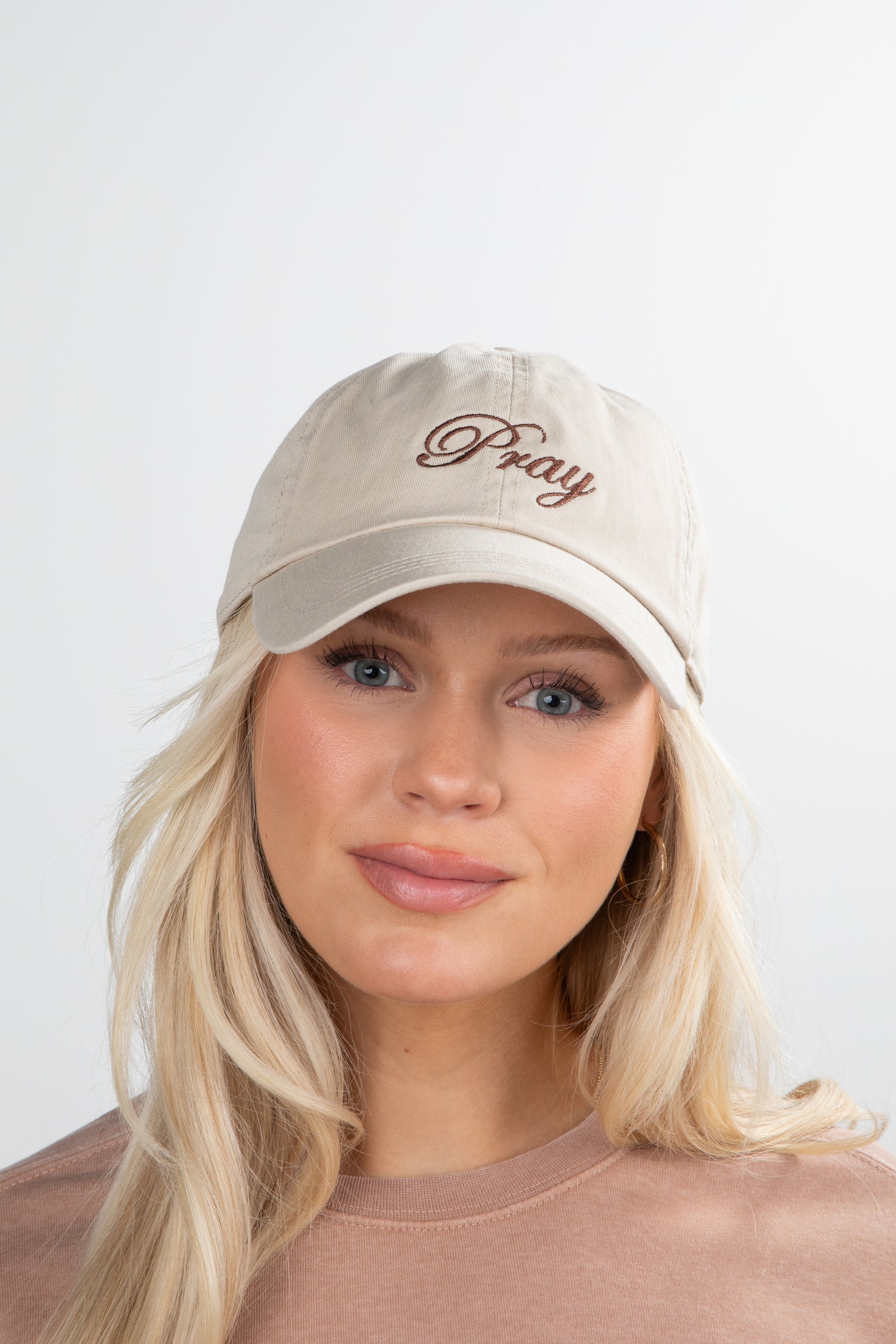 Woman wearing a beige cap with &