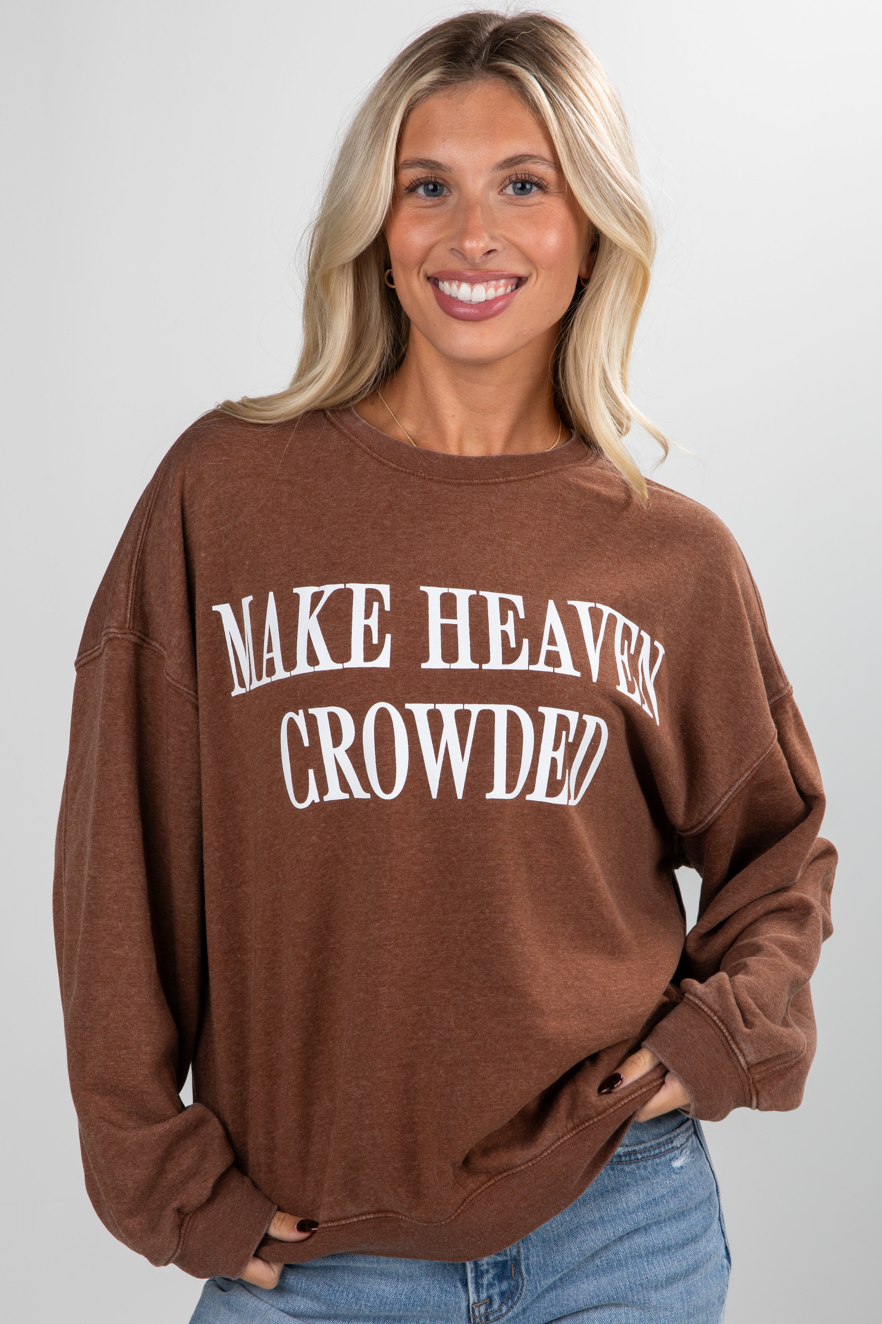 Woman wearing a brown sweatshirt with &