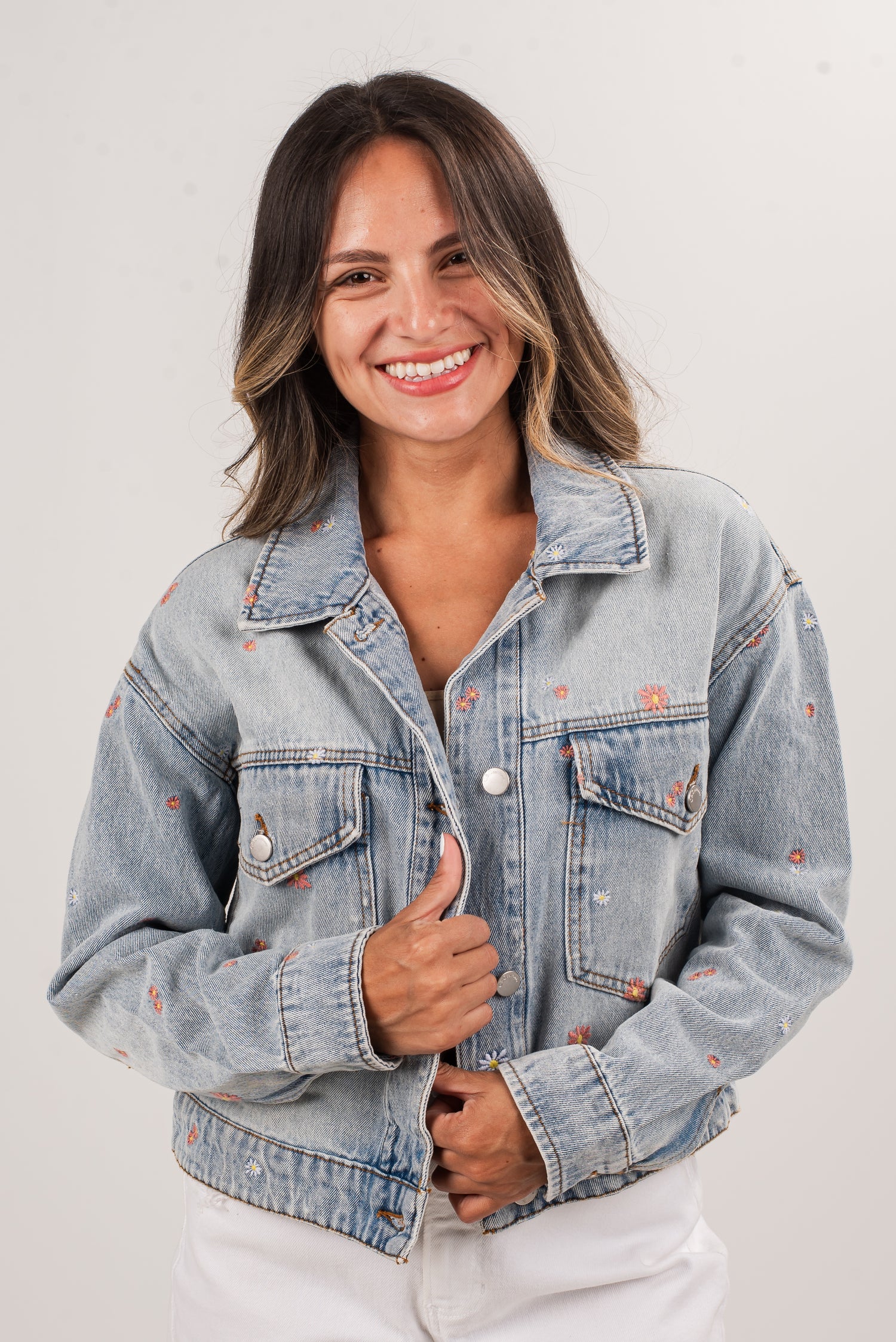 Woman wearing a light blue denim jacket on a white background