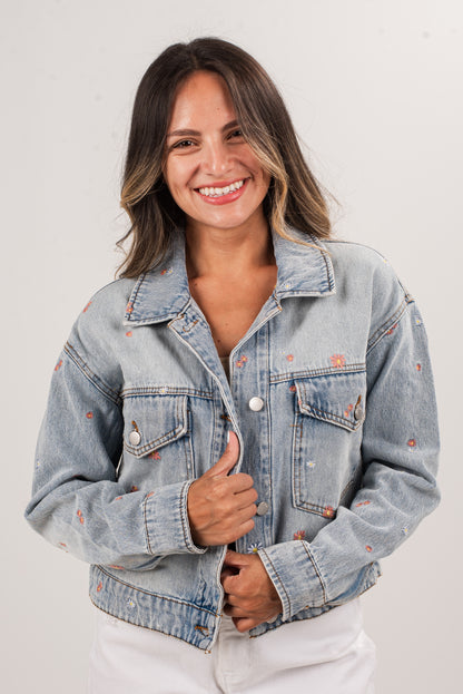 Woman wearing a light blue denim jacket on a white background