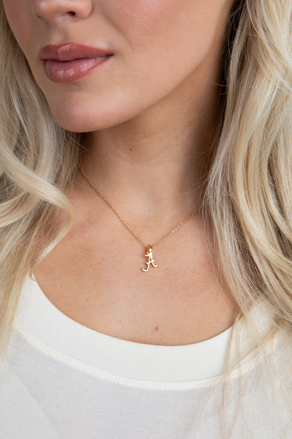 Close-up of a woman wearing a gold necklace with a small pendant.