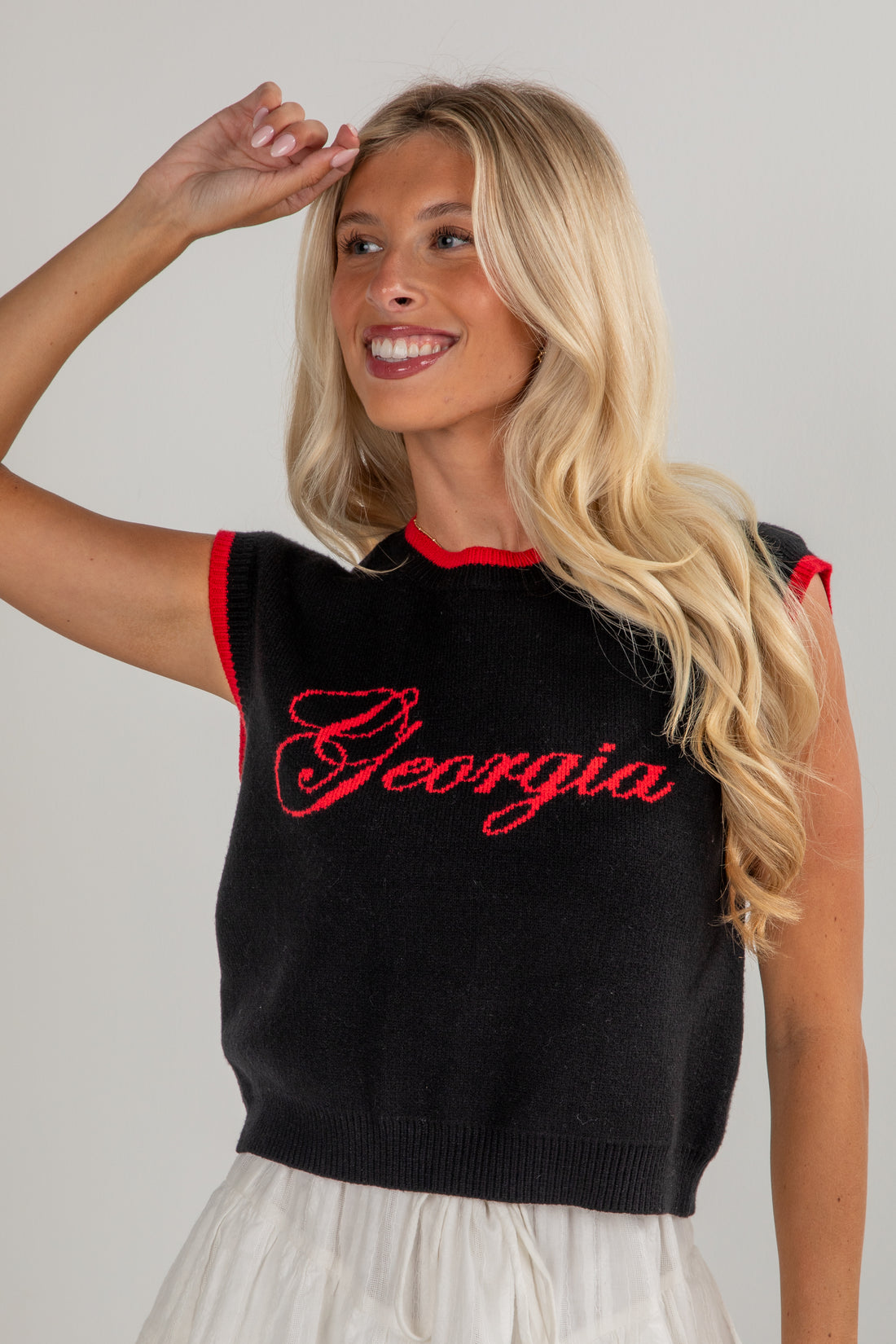 Woman wearing a black sleeveless top with &