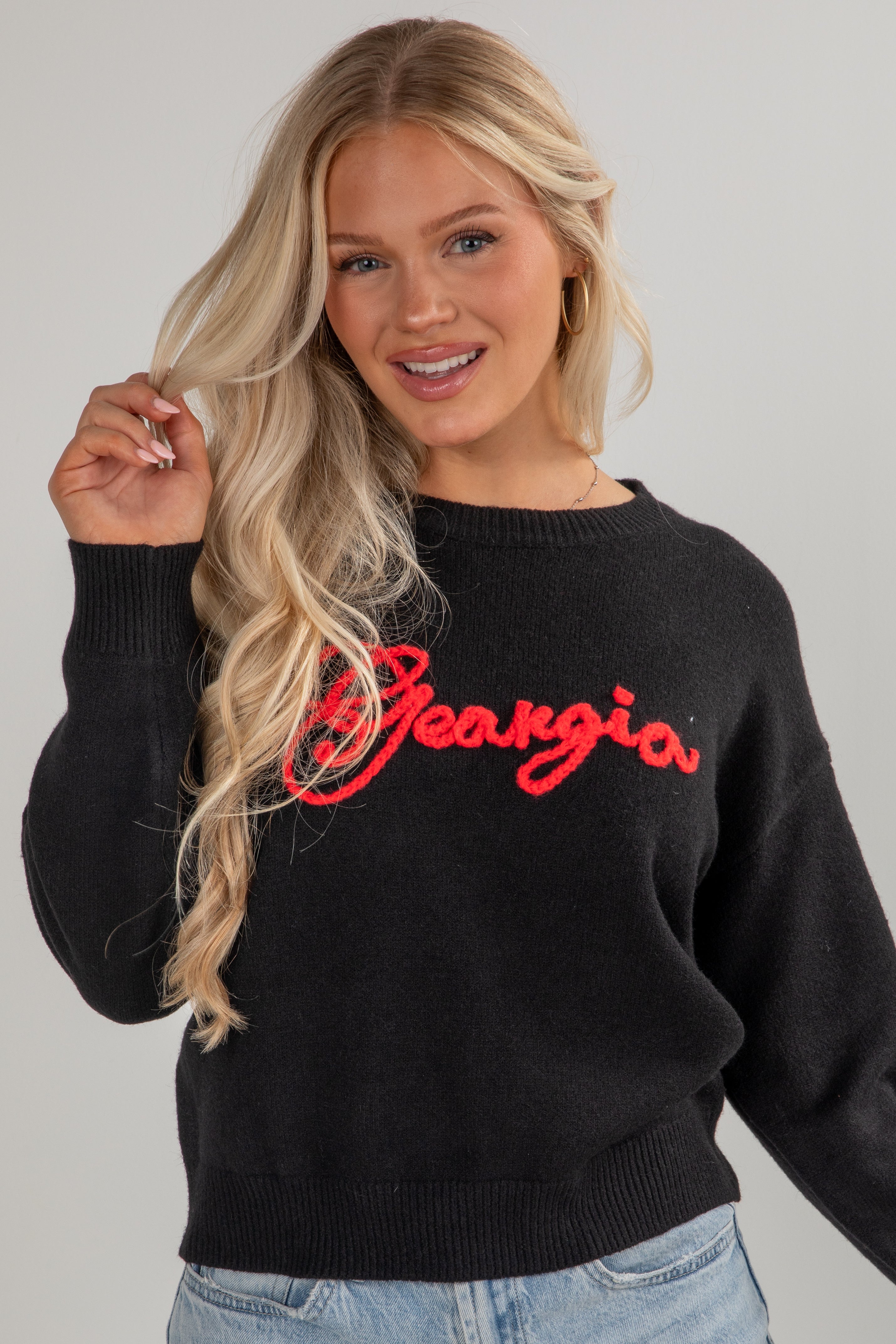 Woman wearing a black sweater with &