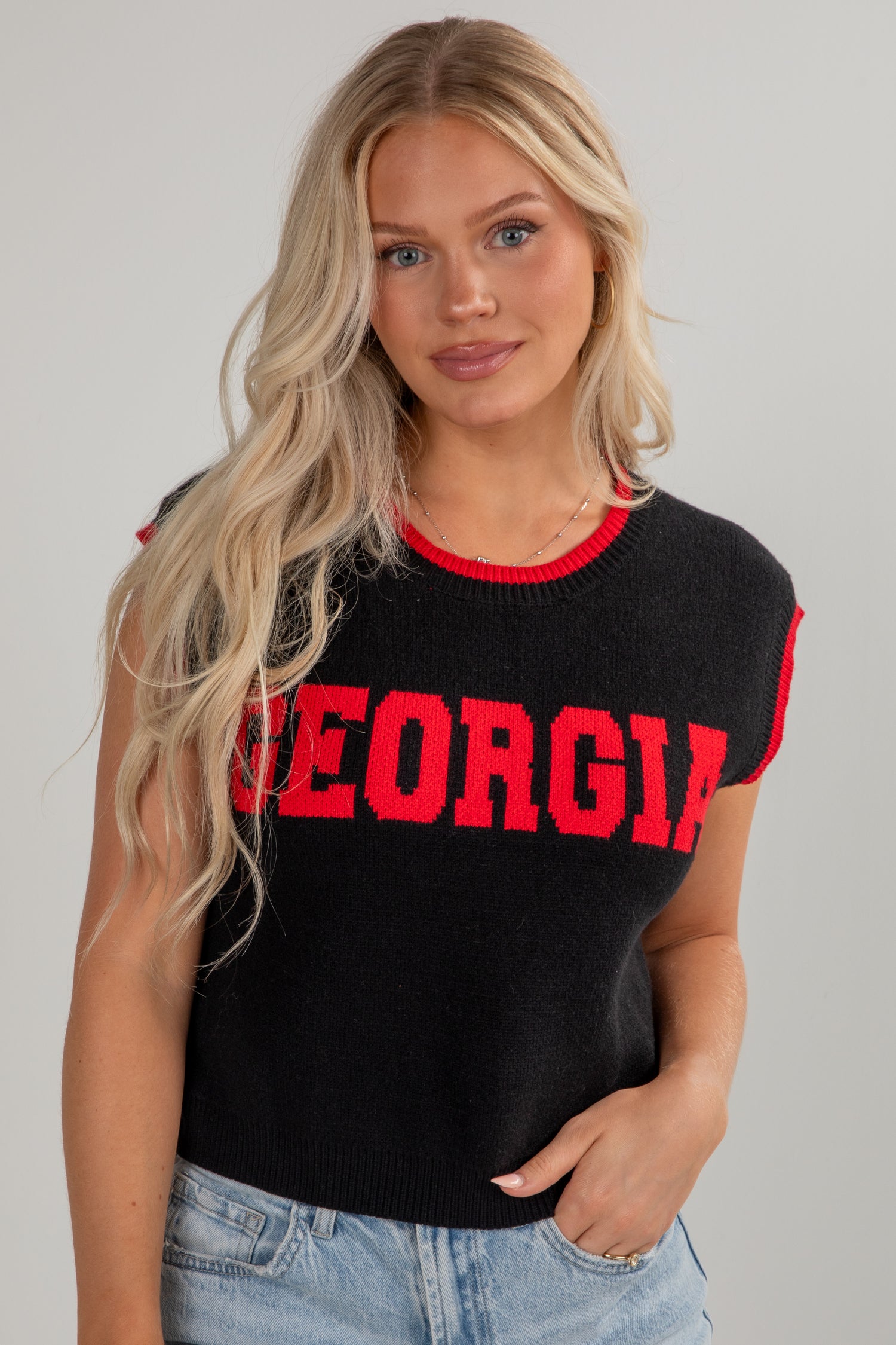 Woman wearing a black sleeveless top with &