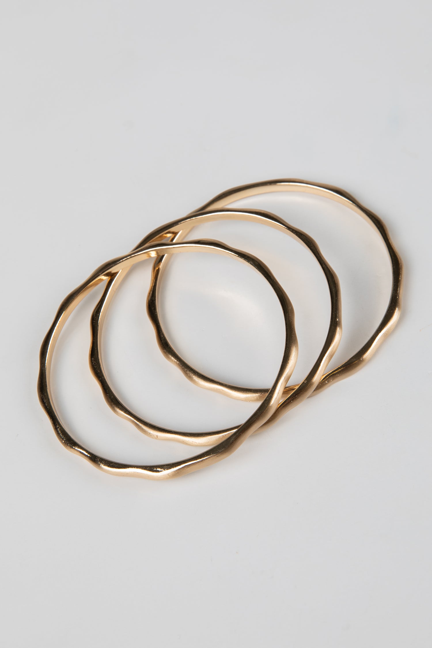 Set of gold hoop earrings on a light gray background