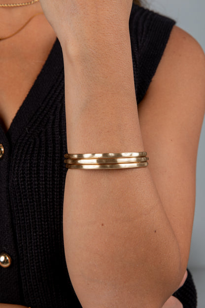 Gold bracelet on a wrist with a blurred background