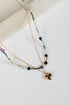 Layered beaded necklaces with a heart charm on a light background