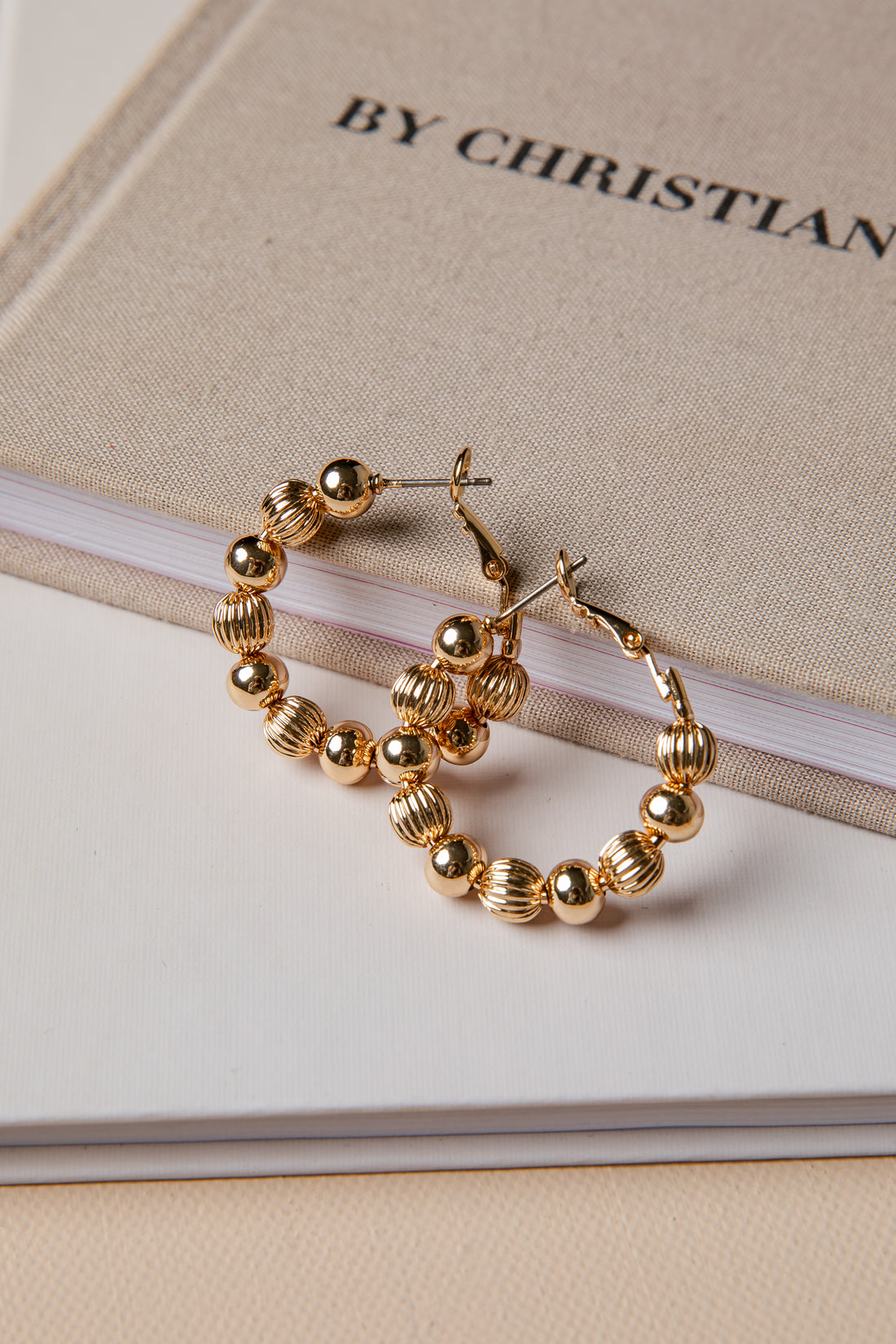 Gold hoop earrings on a book with &