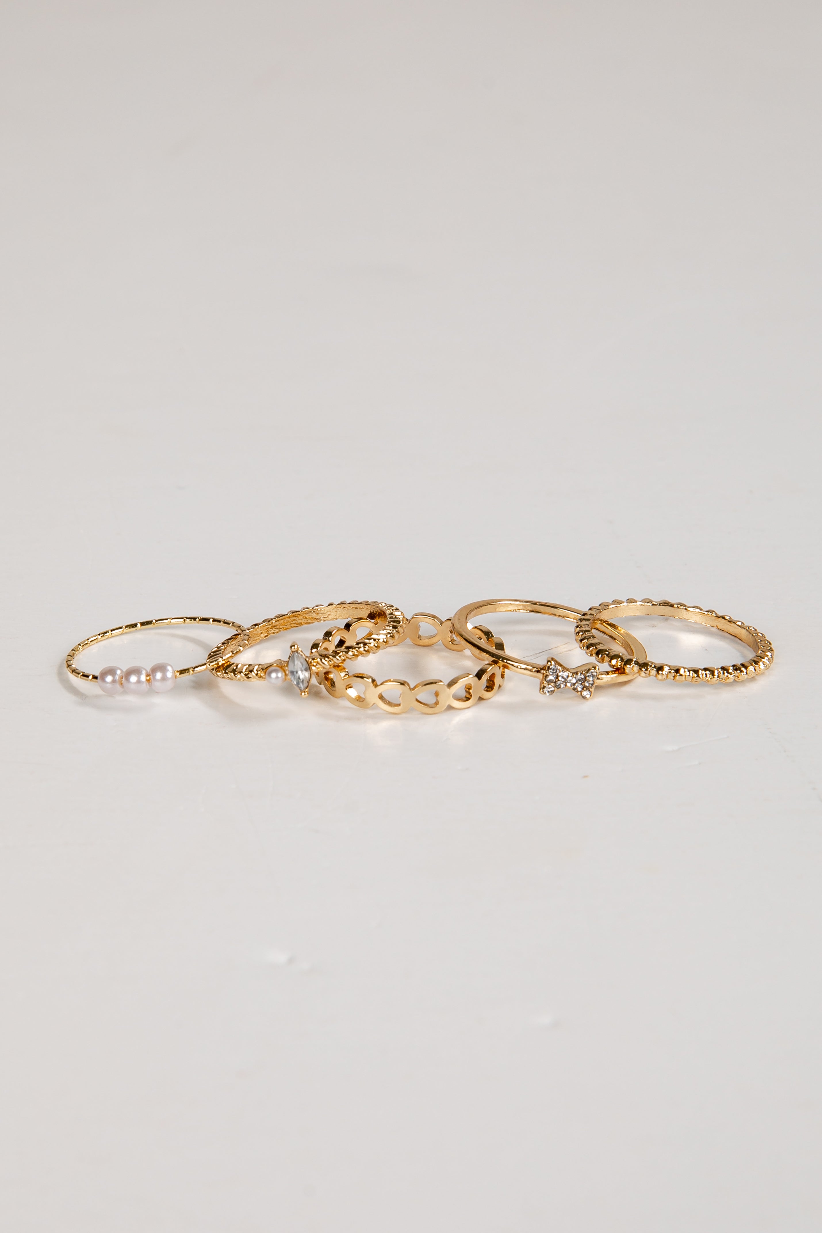 Set of gold rings on a light gray background