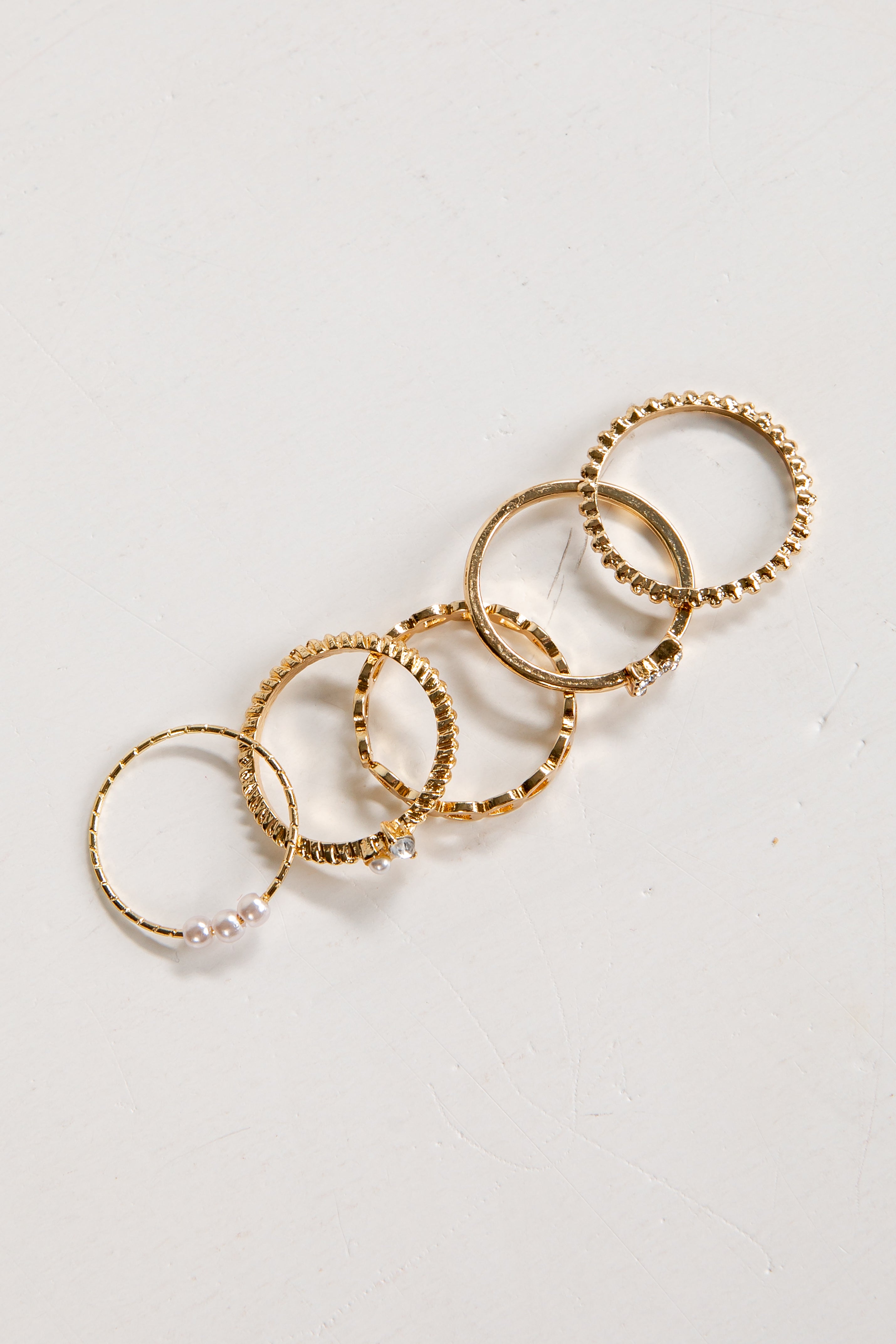 Set of gold rings on a light gray background