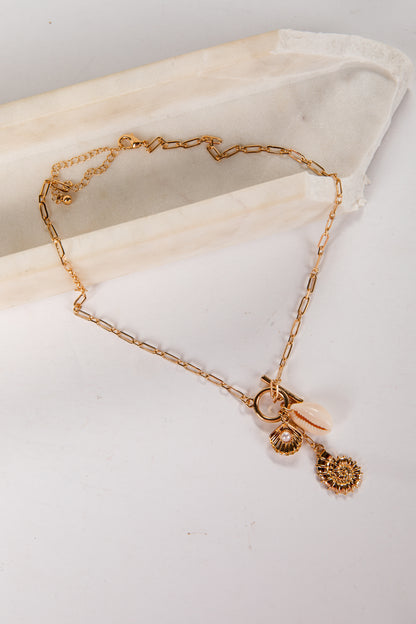 Gold bracelet with charms on a white surface