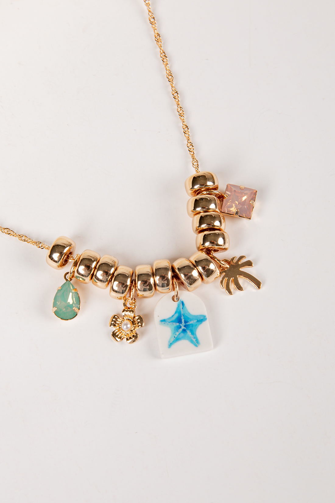 Necklace with various charms on a white background