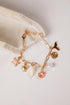 Gold bracelet with various charms on a light background