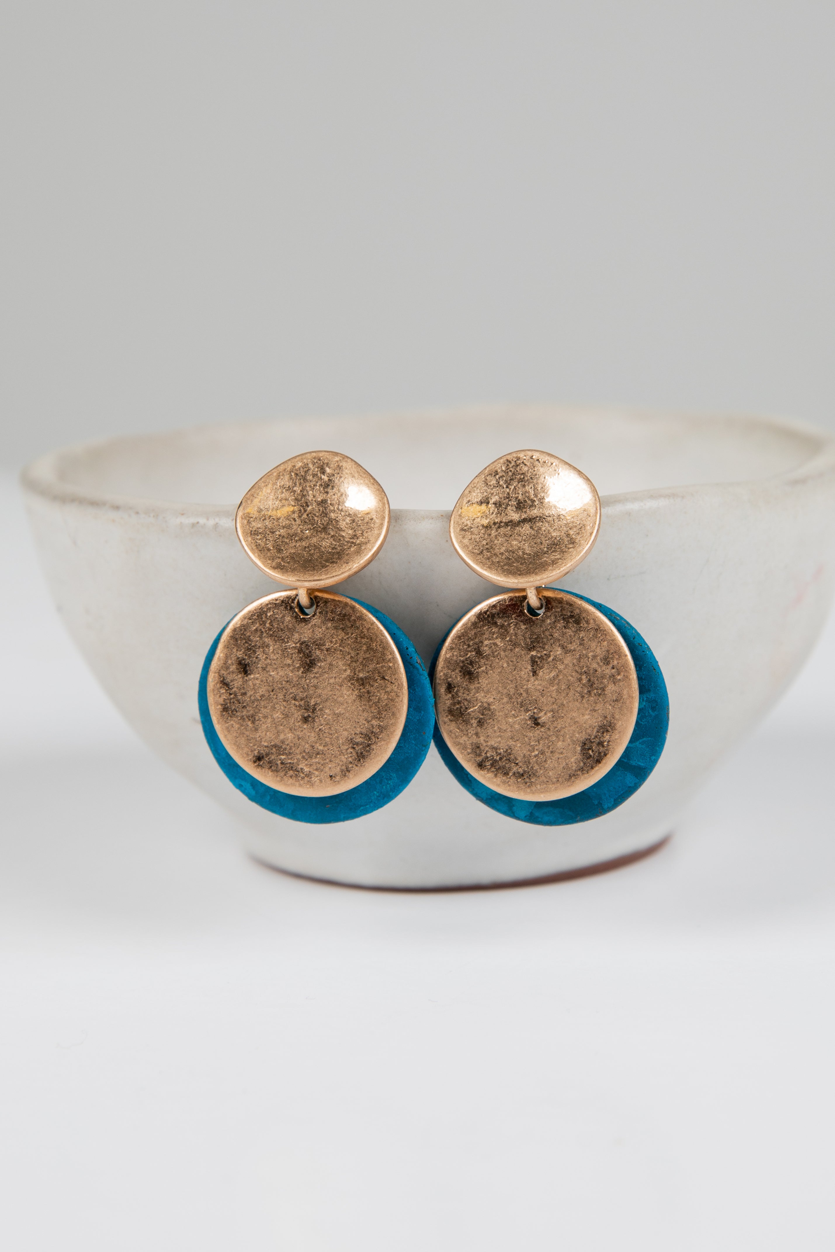 Pair of earrings with gold and blue components on a white background