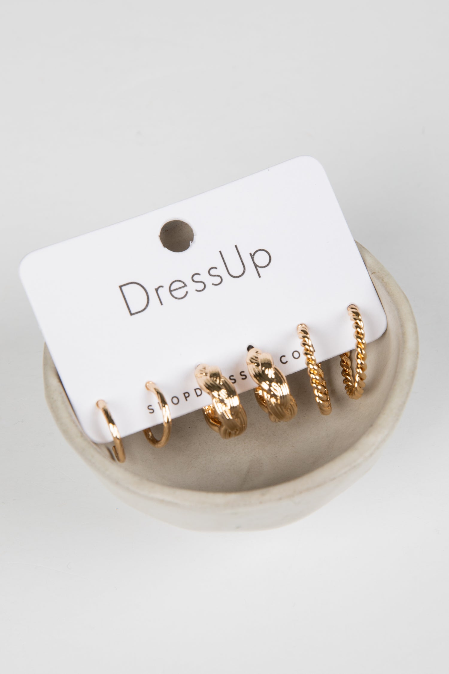 Set of gold hoop earrings on a &