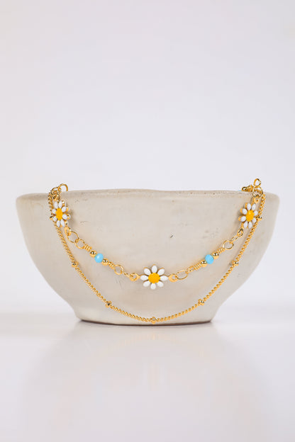 Gold chain necklace with floral pendants on a white background