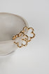 Gold chain earring on a white ceramic dish