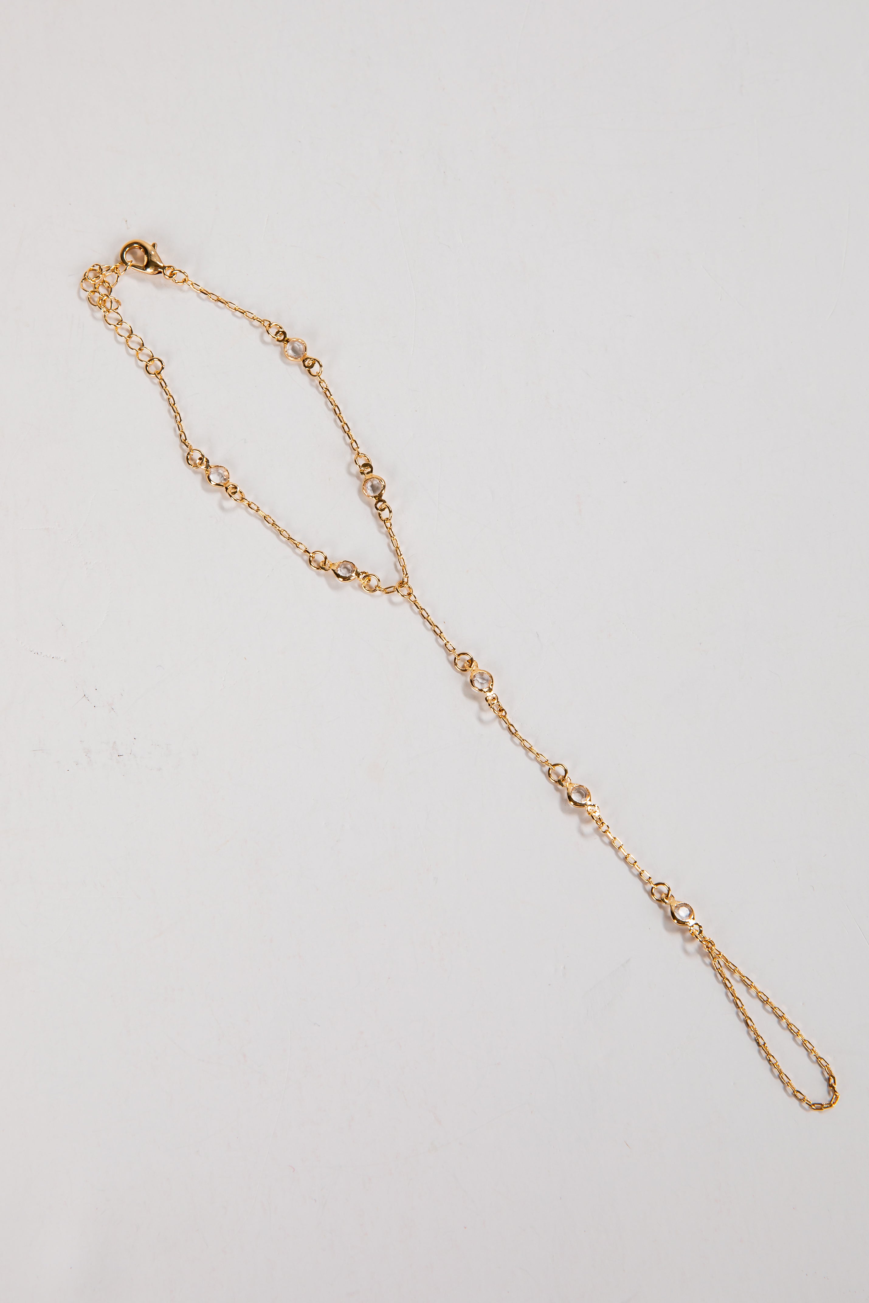 Gold necklace on a light gray background