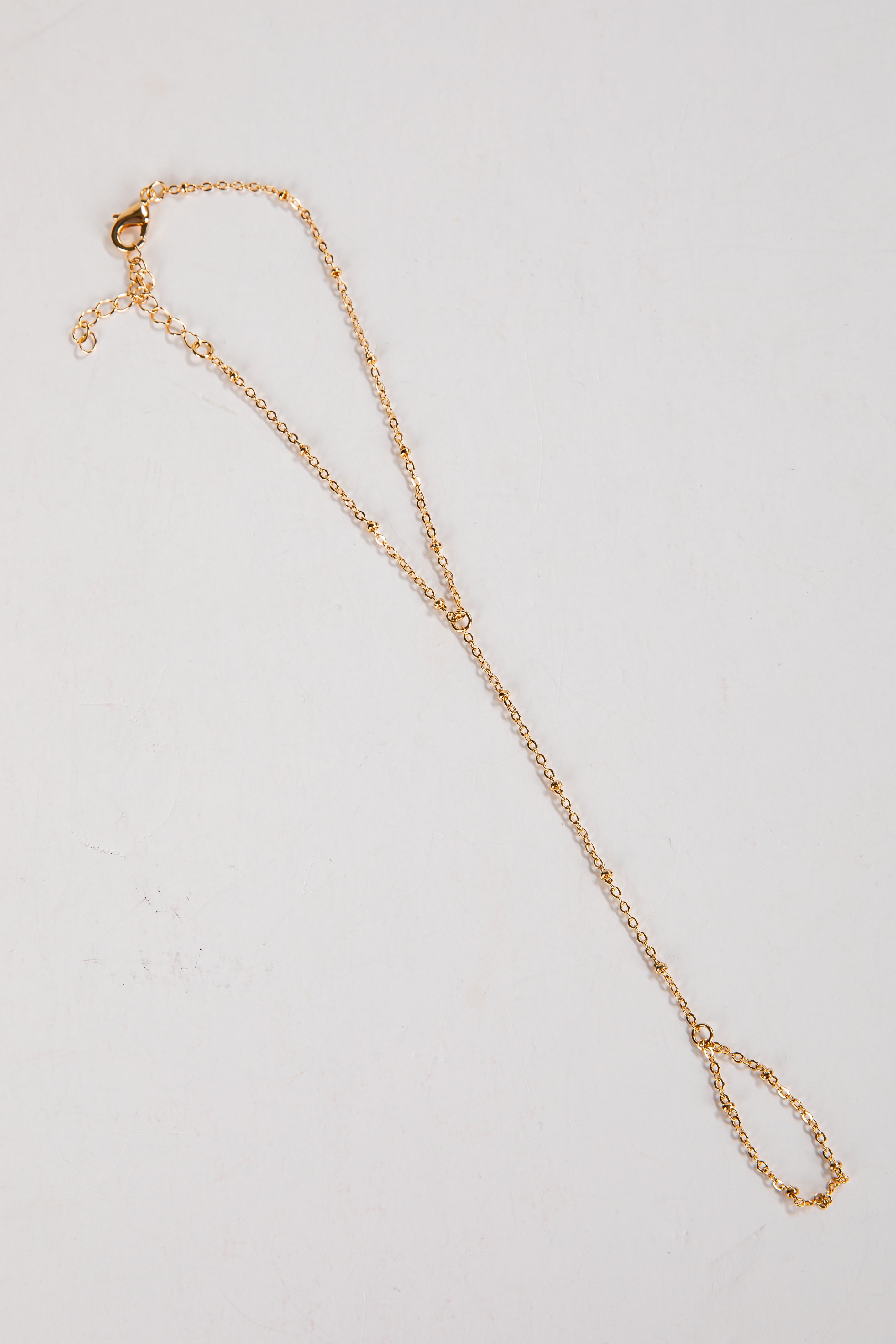 Gold necklace on a light gray background