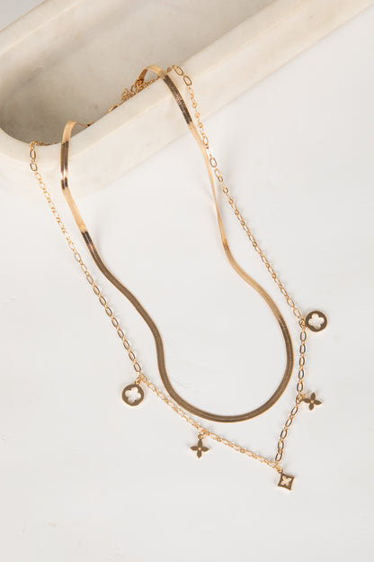 Gold necklaces with small pendants on a light background