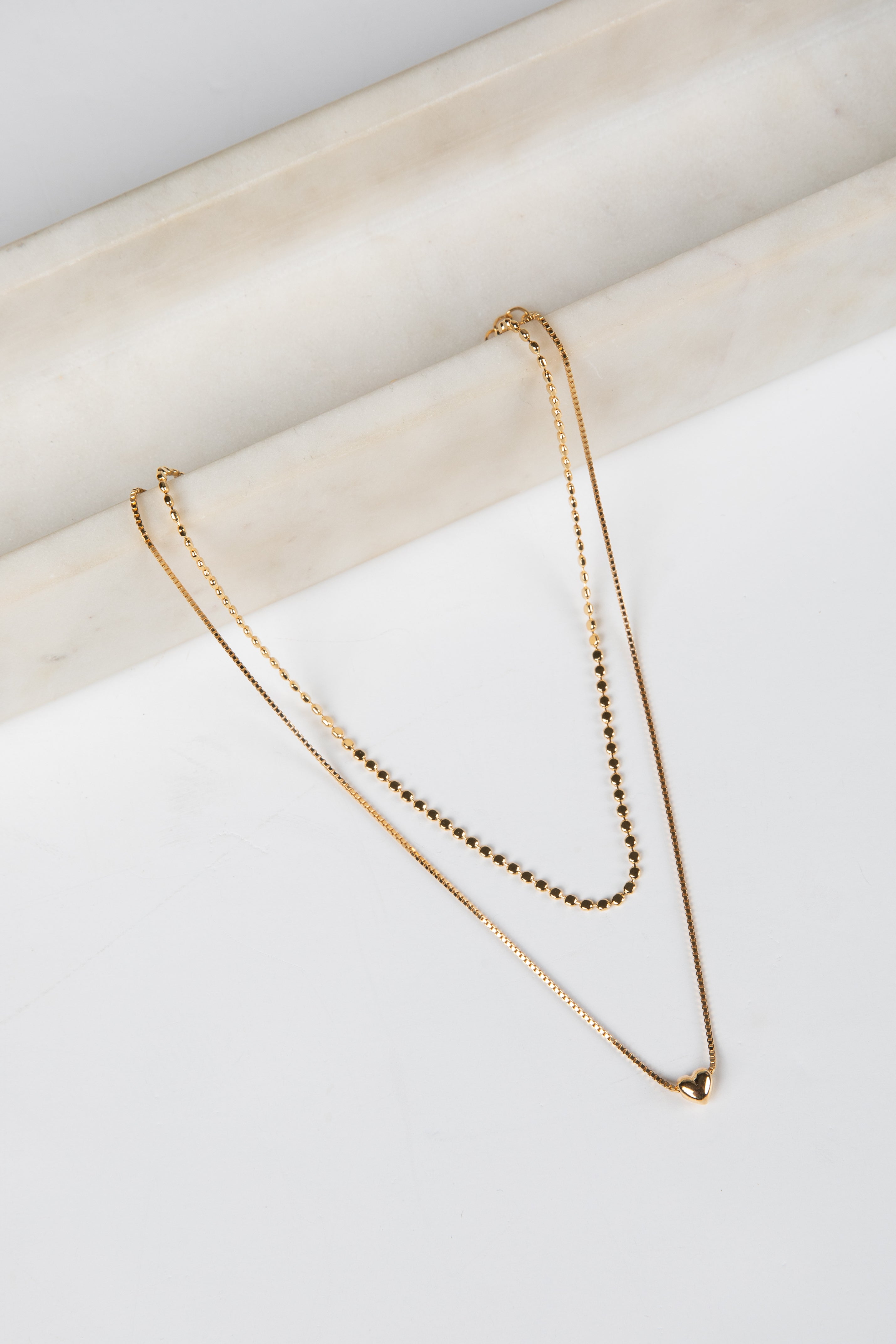 Gold necklace on a white surface