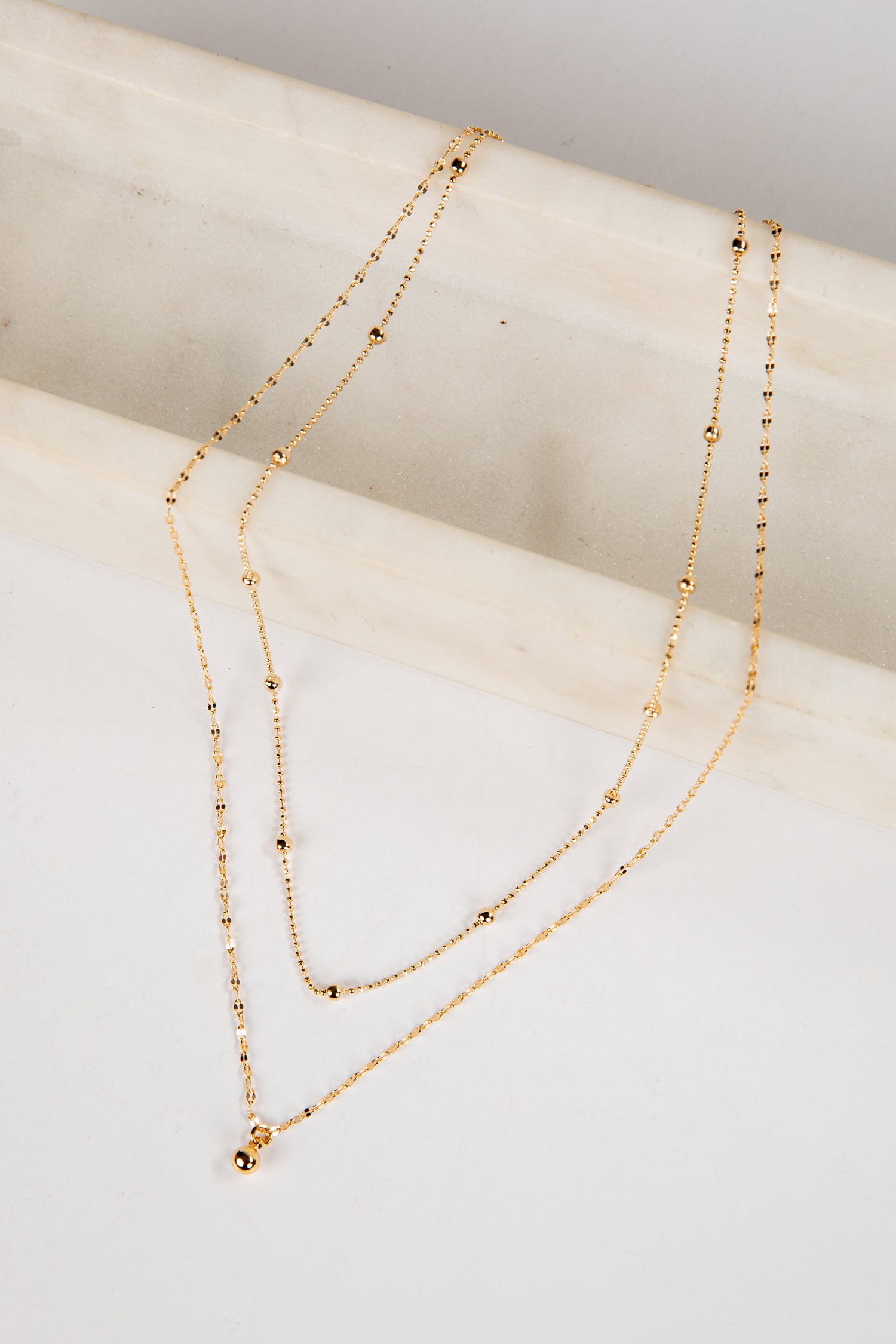 Gold necklace on a white surface