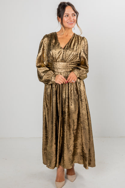 Woman wearing a gold velvet dress against a white background