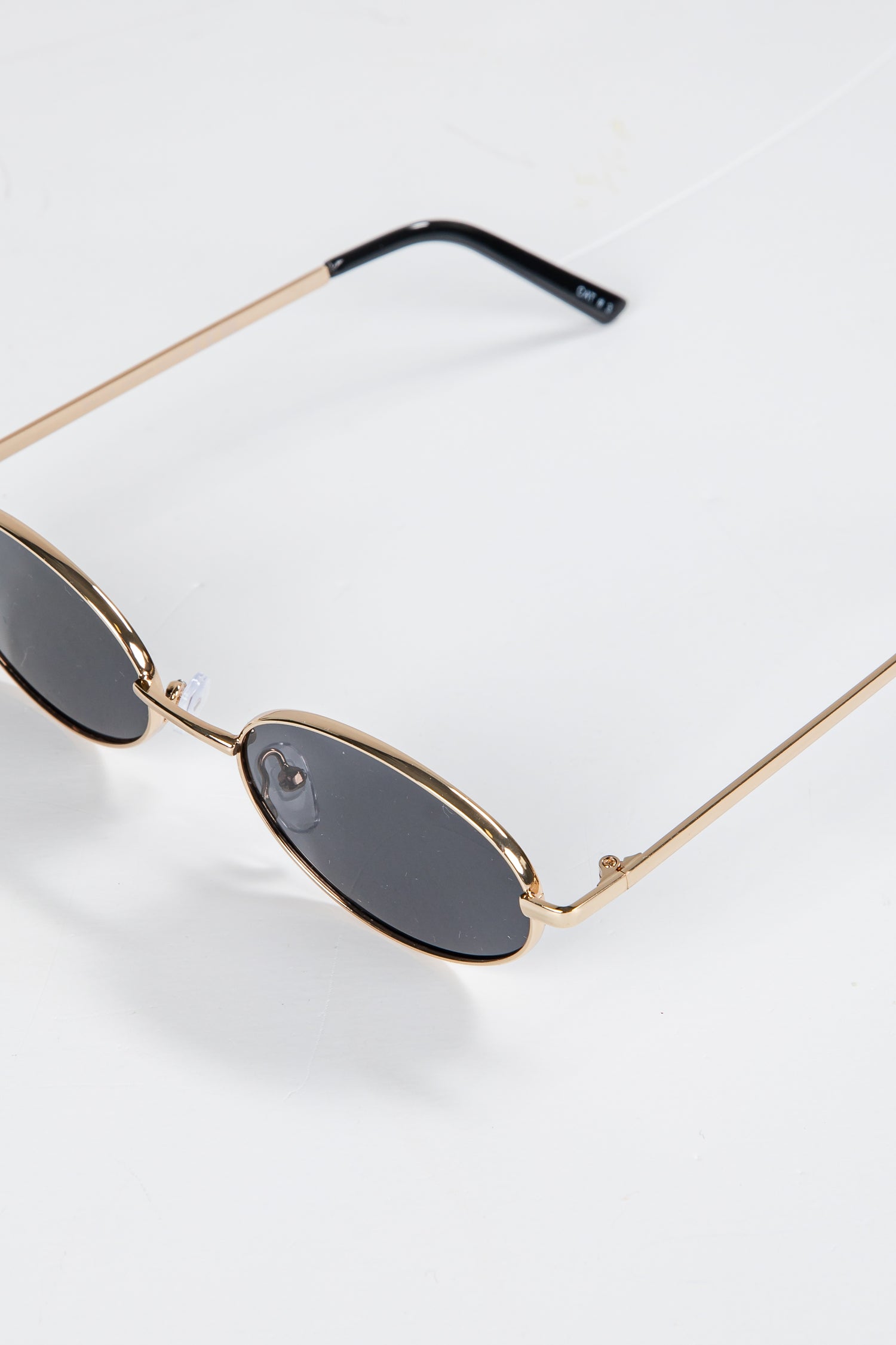 Sunglasses with gold frame and dark lenses on a white background