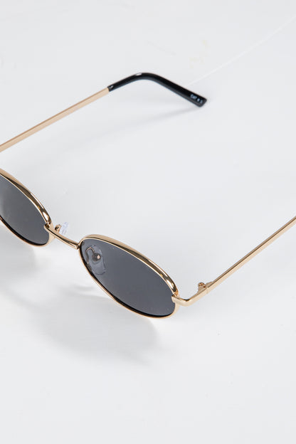 Sunglasses with gold frame and dark lenses on a white background