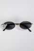 Round sunglasses with gold frame and black lenses on a white background