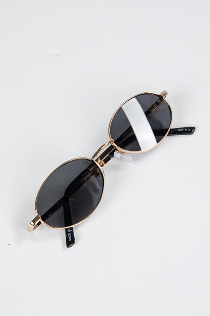 Sunglasses with gold frames and black lenses on a white background