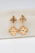 Gold floral earrings on a white background