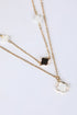 Two gold necklaces with clover pendants on a white background