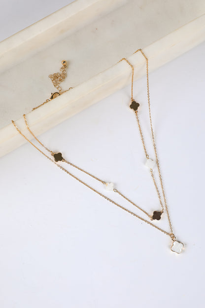 Gold necklace with small pendants on a white surface