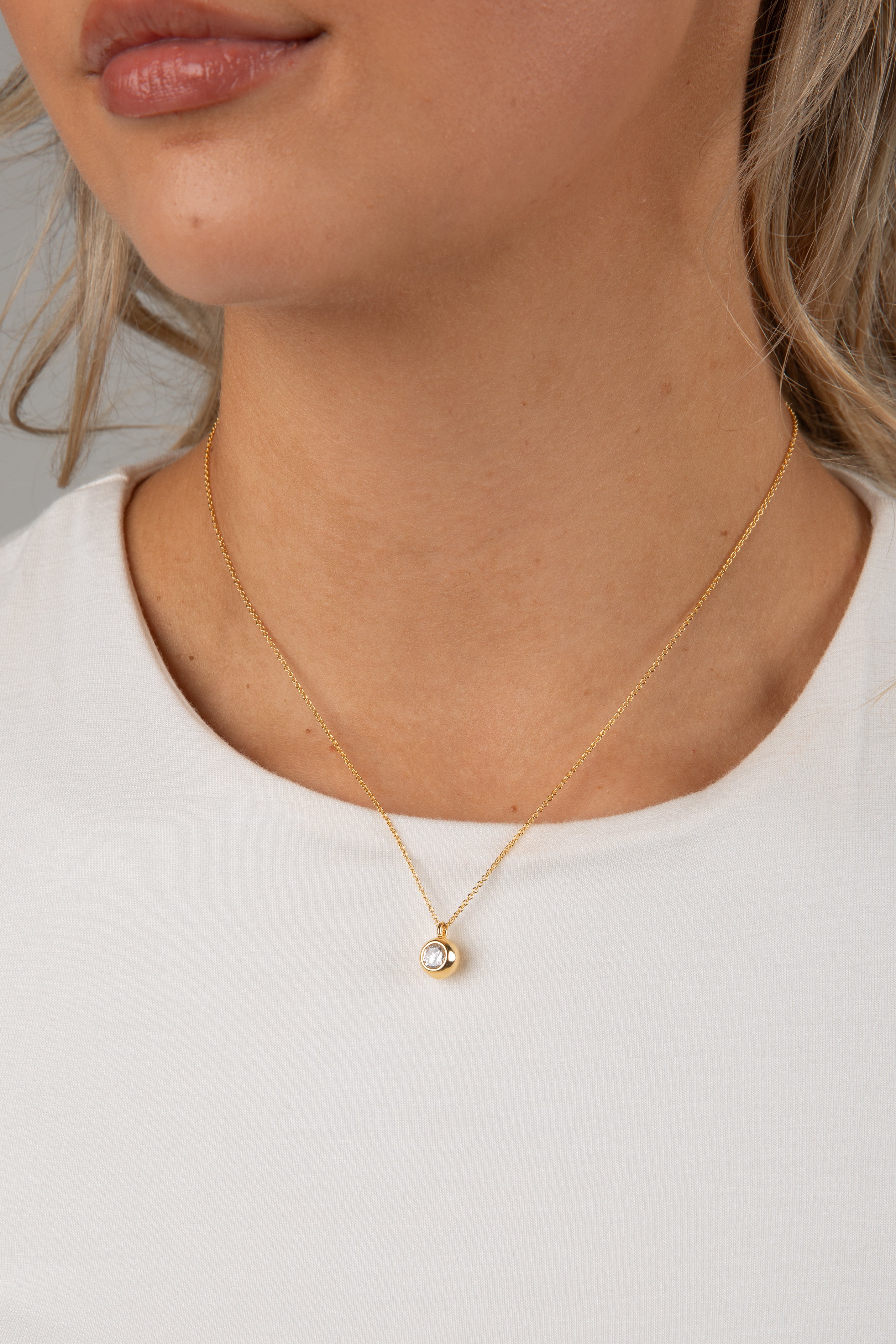 Gold necklace with a pendant on a white background