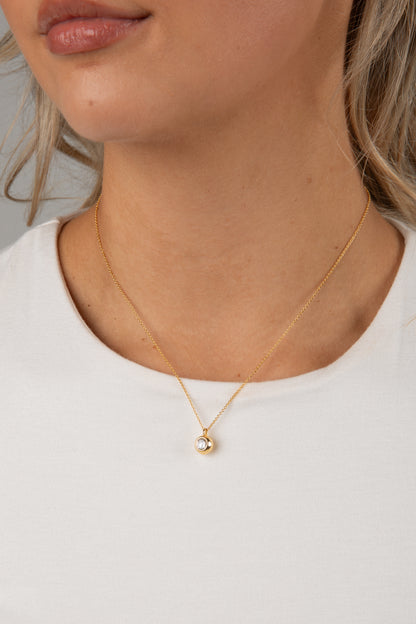 Gold necklace with a pendant on a white background